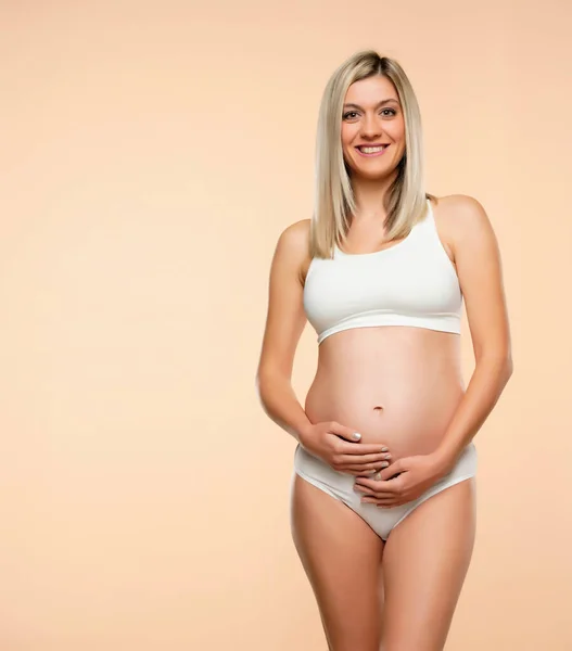 Mujer Embarazada Joven Lencería Posando Sobre Fondo Beige —  Fotos de Stock