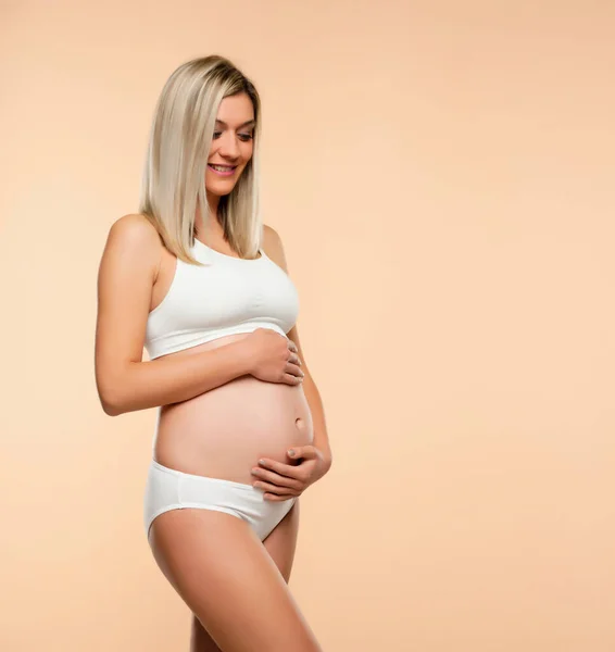 Mujer Embarazada Joven Lencería Posando Sobre Fondo Beige —  Fotos de Stock
