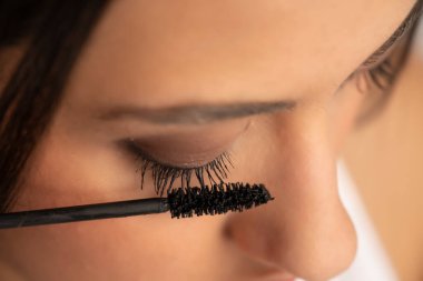 Genç bir kadının yüzüne maskara sürmüş.