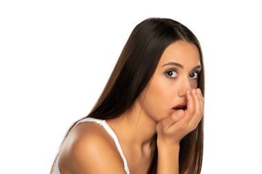 Genç bir kadın nefesini beyaz bir arka planda tutar.