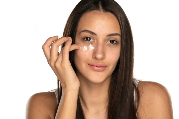Uma Jovem Mulher Bonita Aplica Creme Facial Fundo Branco — Fotografia de Stock