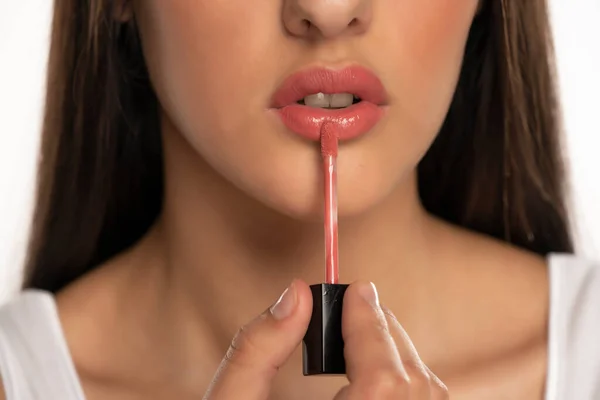 Closeup Woman Applying Lip Gloss Her Lips White Background — Stock Photo, Image