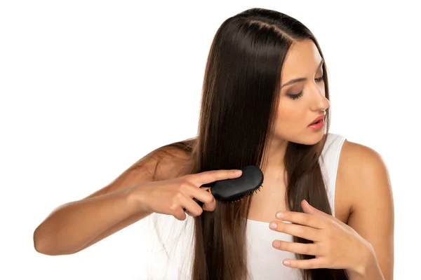 Wanita Muda Menyikat Rambut Panjangnya Lurus Pada Latar Belakang Putih — Stok Foto
