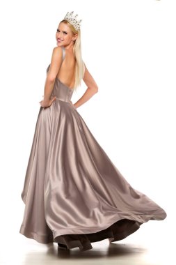 Taçlı genç bayan ve gece elbisesi beyaz arka planda poz veriyor