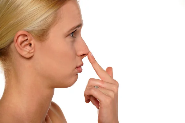Genç Üzgün Kadın Beyaz Bir Arka Planda Parmağıyla Burnuna Dokunur — Stok fotoğraf