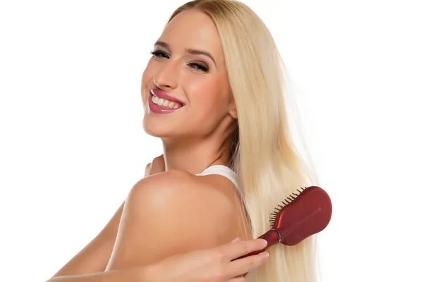 Güzel Sarışın Kadın Beyaz Bir Arka Planda Saçını Tarıyor — Stok fotoğraf