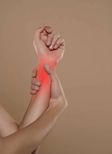手首を持っている女性はベージュの背景に痛みを伴う手首のスポットに 神経疾患 ヘルスケアと医療の概念 — ストック写真