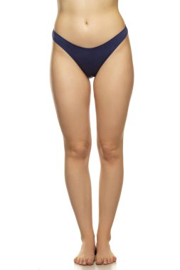 Beyaz arka planda güzel kadın bacakları ve koyu mavi külotlar.