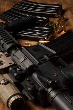 Optik görüşlü m4 tüfek, mühimmat ve mermiler ahşap masada.