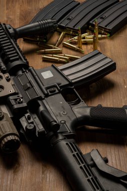 Optik görüşlü m4 tüfek, mühimmat ve mermiler ahşap masada.