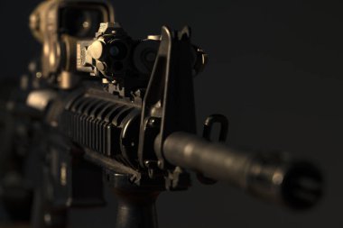 Optik görüşlü m4 tüfek ve koyu arkaplanda lazer cihazı.