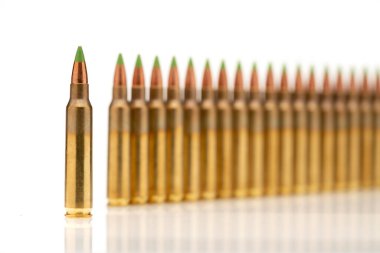 5.56 kalibrelik yeşil uçlu mermilerden oluşan bir grup beyaz arka planda sıraya dizildi.