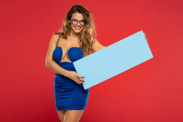 Lachende Mooie Vrouw Met Blauw Leeg Reclamebord Rode Achtergrond — Stockfoto