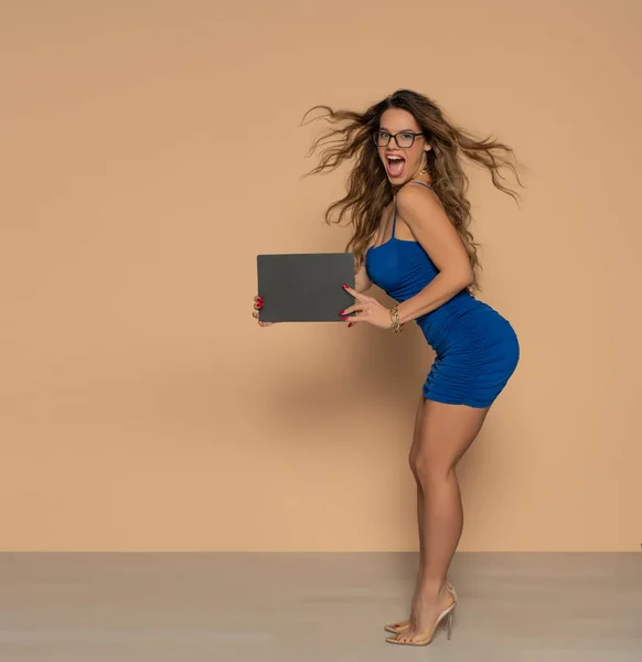 베이지 배경에 파란색빈 광고판을 아름다운 여자가 — 스톡 사진