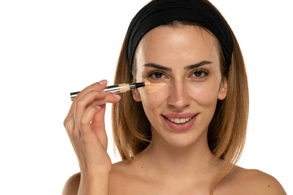 Junge Lächelnde Frau Beklatscht Concealer Unter Ihren Augen Auf Weißem — Stockfoto