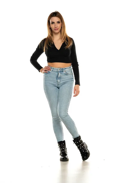 Encantadora Joven Posando Estudio Blusa Corta Negra Jeans Azules Botas —  Fotos de Stock