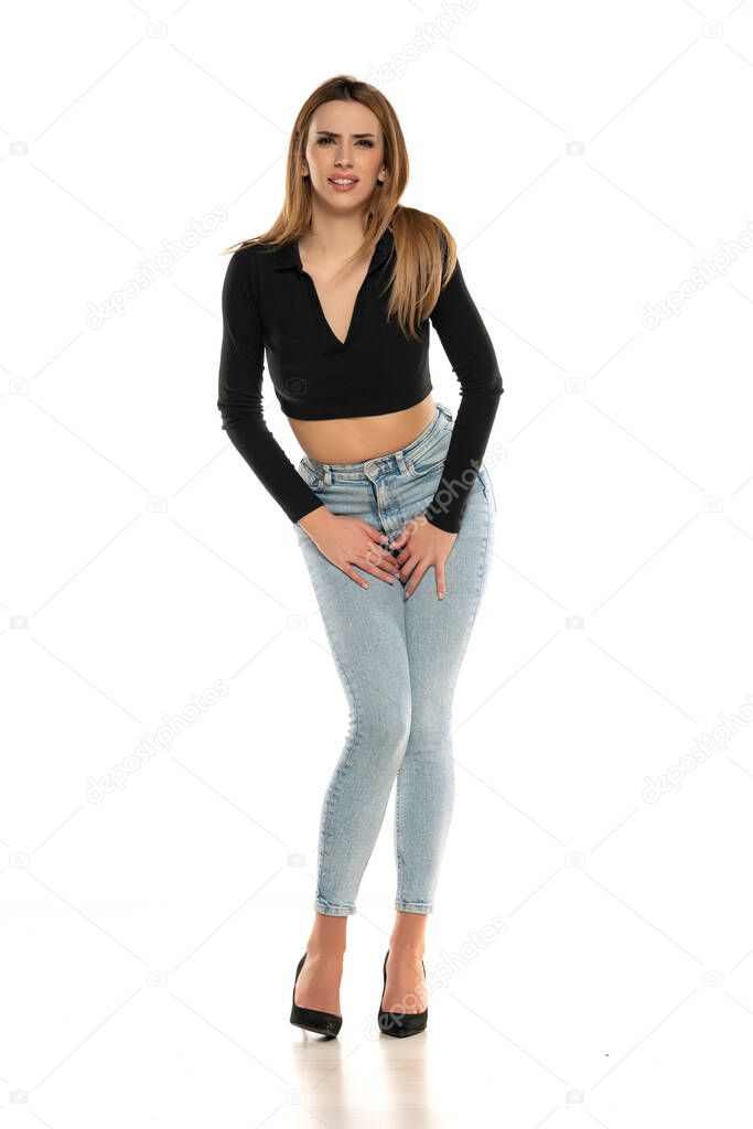Young woman pressed her hands to the lower abdomen. Medical concept. white background
