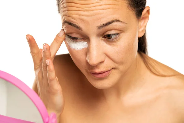 Junge Frau Trägt Kosmetikprodukt Unter Dem Auge Auf Weißem Hintergrund — Stockfoto