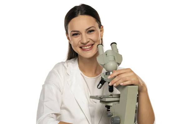 Portret Van Lachende Vrouwelijke Wetenschapper Met Microscoop Een Witte Achtergrond — Stockfoto