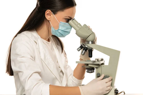 Cientista Feminina Com Máscara Protetora Olhando Através Microscópio Fundo Branco — Fotografia de Stock