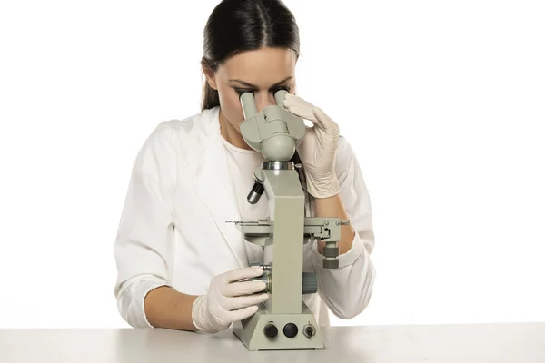 Uma Jovem Cientista Olha Através Microscópio Estúdio Fundo Branco — Fotografia de Stock