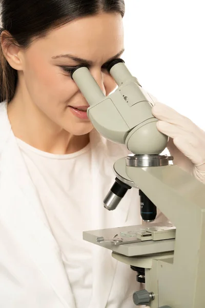 Vrouwelijke Lachende Wetenschapper Kijkend Door Een Microscoop Close Witte Achtergrond — Stockfoto