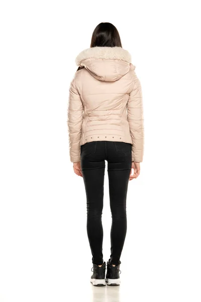 겨울용 자켓을 여자의 뒷모습 과하얀 배경에 청바지를 — 스톡 사진