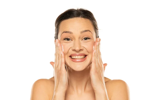 Beleza. close-up de menina bonita e natural com sorriso branco e ombros nus  rindo, sorrindo despreocupado. mulher jovem sem maquiagem mostrando efeito  após cosméticos, parede branca