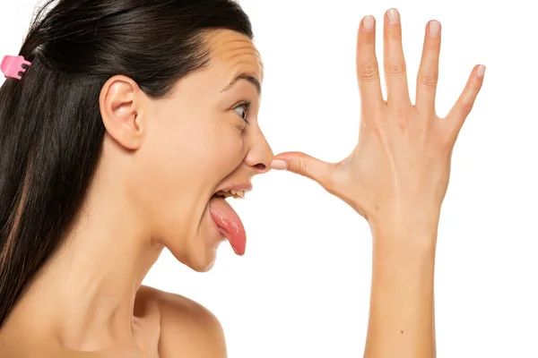 白い背景に鼻の上の手のひらでモンクしている女性のプロフィール — ストック写真