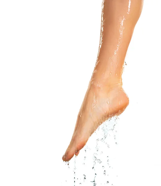 白い背景の上に水が滑っている女性の濡れた足の近くに — ストック写真