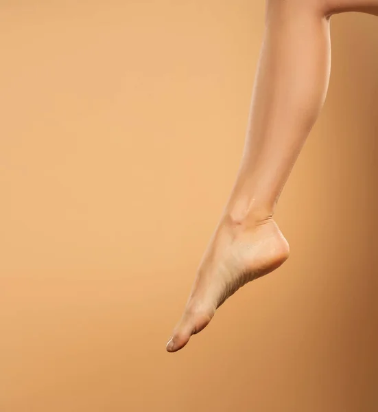 Piękna Gładka Noga Kobiety Goła Stopa Laserowej Depilacji Beżowym Tle — Zdjęcie stockowe