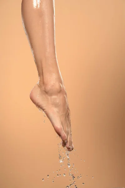Крупный План Женской Мокрой Ноги Водой Скользящей Над Ней Бежевом — стоковое фото