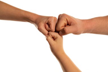 Farklı nesilden aile elleri yumruk tokuşturuyor. Elle yapılan başarılı bir iş birliği jest iletişimi. Aile ortaklığı aile birlikte çalışır uyum ve güven kavramı.
