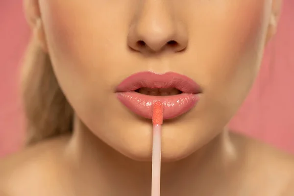 Close Beautiful Young Woman Applying Lipgloss Pink Background — 스톡 사진