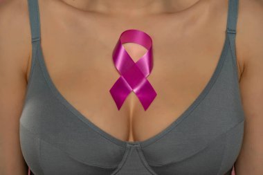 Kanser Farkındalığı kurdeleli gri sutyenli genç bayanı kapatın..