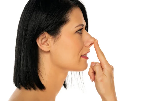 中年女性タッチ彼女の鼻とともに彼女の指で白い背景 — ストック写真