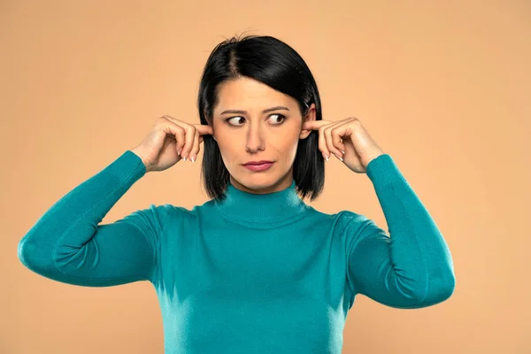 Middle Aged Woman Plugging Her Ears Fingers Beige Background — Fotografia de Stock