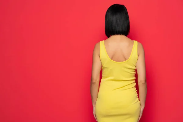 Rear View Standing Woman Yellow Tight Dress Isolated Red Background — ストック写真