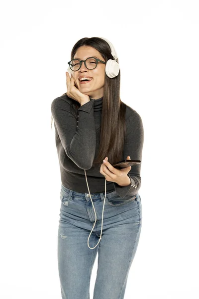 Mujer Joven Usando Teléfono Para Escuchar Música Sobre Fondo Blanco — Foto de Stock