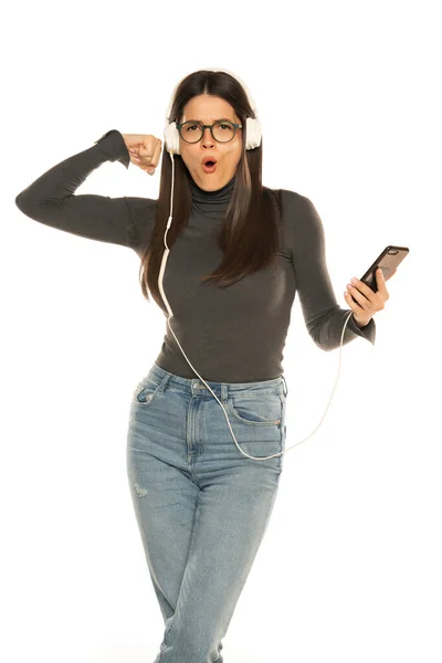 Mujer Joven Usando Teléfono Para Escuchar Música Sobre Fondo Blanco — Foto de Stock