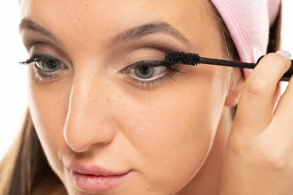Closeup Woman Applying Mascara White Background — стоковое фото