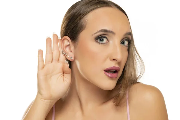 Genç Bir Kadın Beyaz Bir Arka Planı Dinlerken Elini Kulağının — Stok fotoğraf