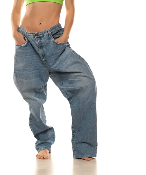 Ernährungskonzept Und Gewichtsverlust Frau Oversize Jeans Auf Weißem Hintergrund Nahaufnahme — Stockfoto