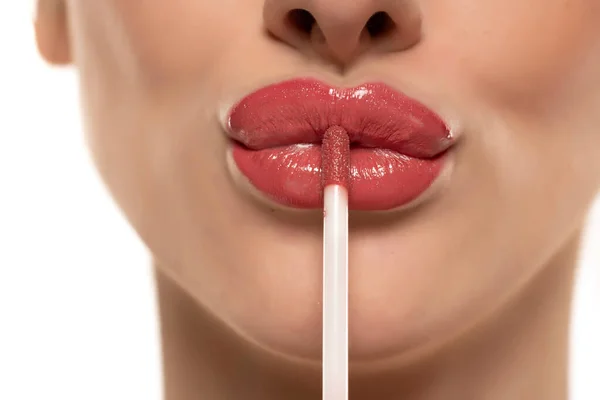 Wanita Cantik Muda Menerapkan Lip Gloss Bibirnya Pada Latar Belakang — Stok Foto