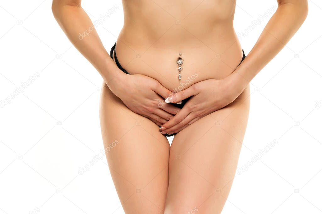 Young female suffering form abdominal pain on white background . Causes of abdominal pain include dysmenorrhea, endometriosis, PMS or ovarian cyst. Gynecology and health care concept.