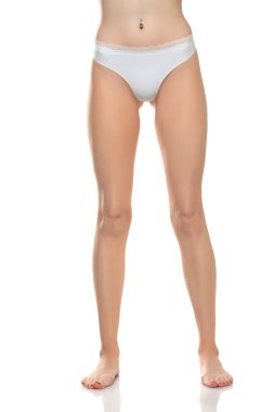 Beyaz bikini külotlu, beyaz stüdyo arka planında çıplak ayaklı kadın manzarası..