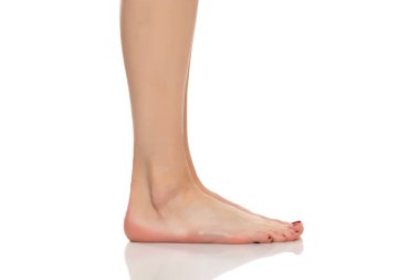 Beyaz arka planda güzel bakımlı kadınların ayaklarının yan görünüşü.