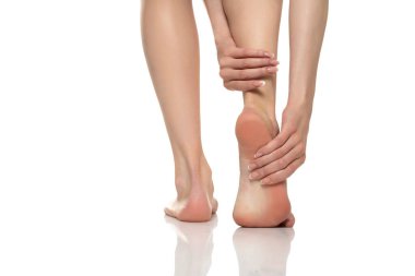 Beyaz stüdyo arka planında kadınlara ayak ağrısı. Acı kavramı.