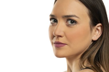 Beyaz arka planda mavi gözlü ve makyajlı güzel bir kadının portresi..