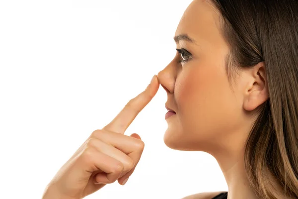 Young Woman Touches Her Nose Her Finger White Background — Stock Photo, Image